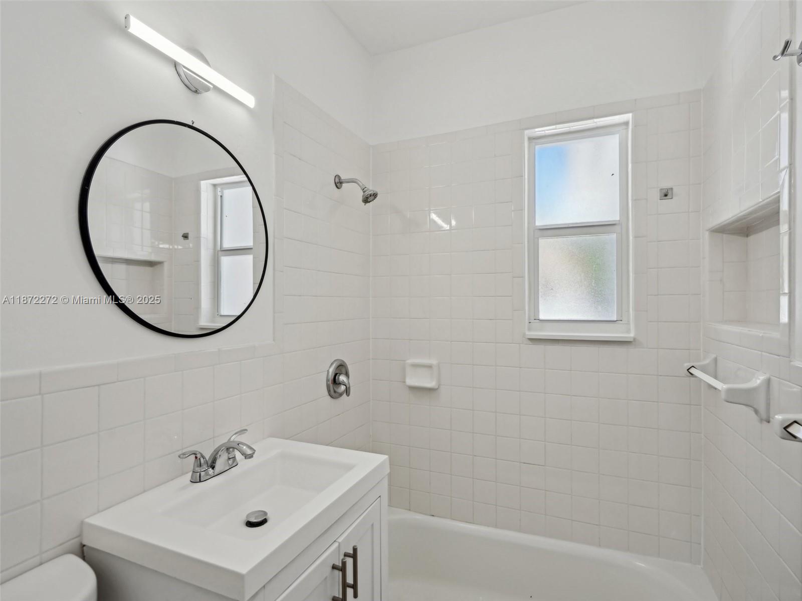 8875 Abbott Avenue Surfside, FL 33154 - Photo 17 of 45 a bathroom with a sink a mirror a vanity and a shower