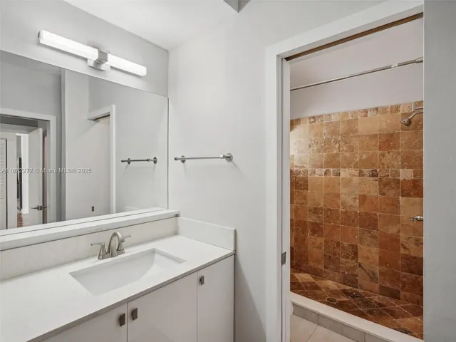 a bathroom with a shower sink and mirror