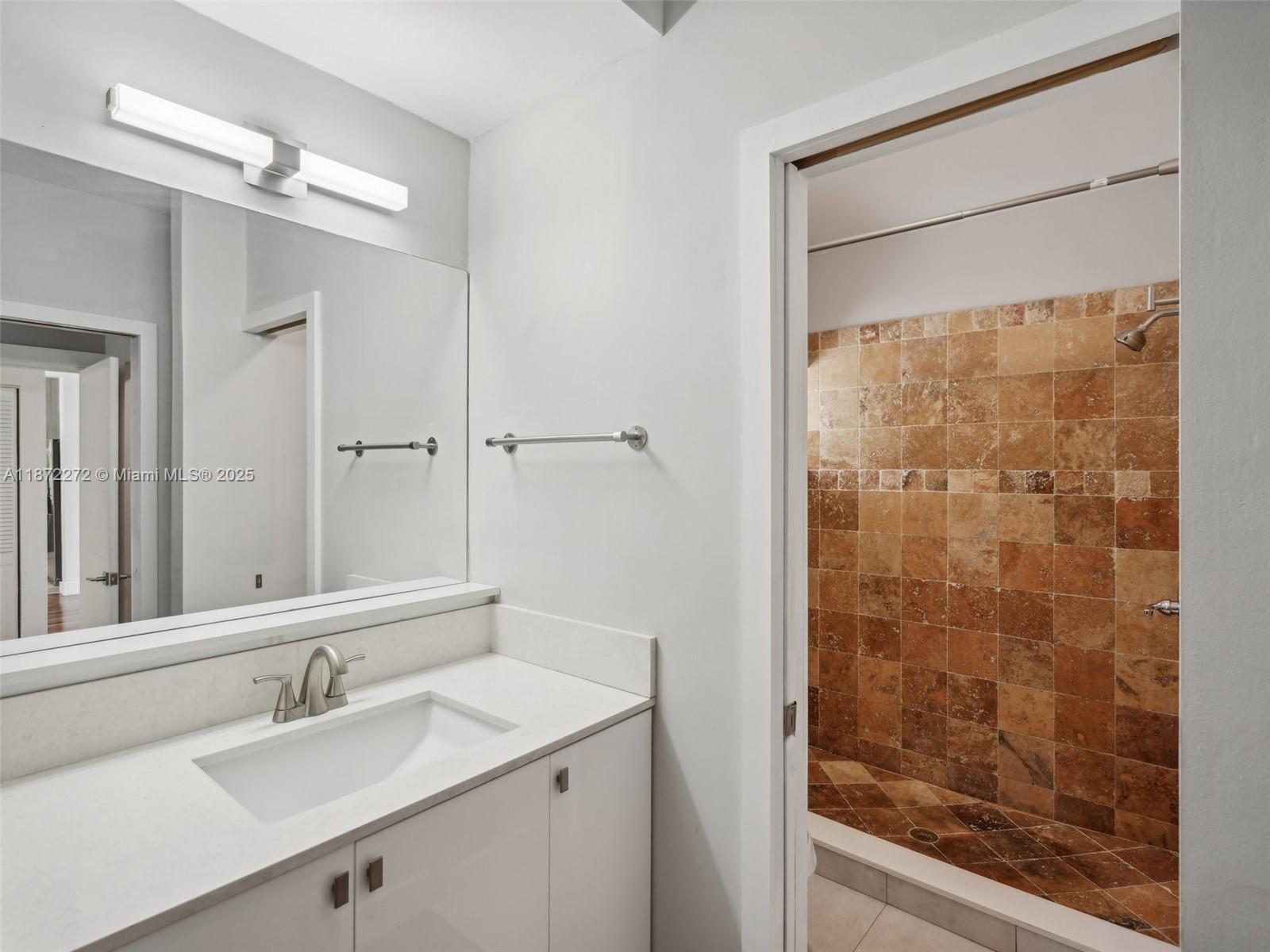 8875 Abbott Avenue Surfside, FL 33154 - Photo 21 of 45 a bathroom with a shower sink and mirror