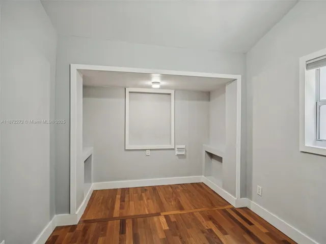 a view of a room with wooden floor and white walls