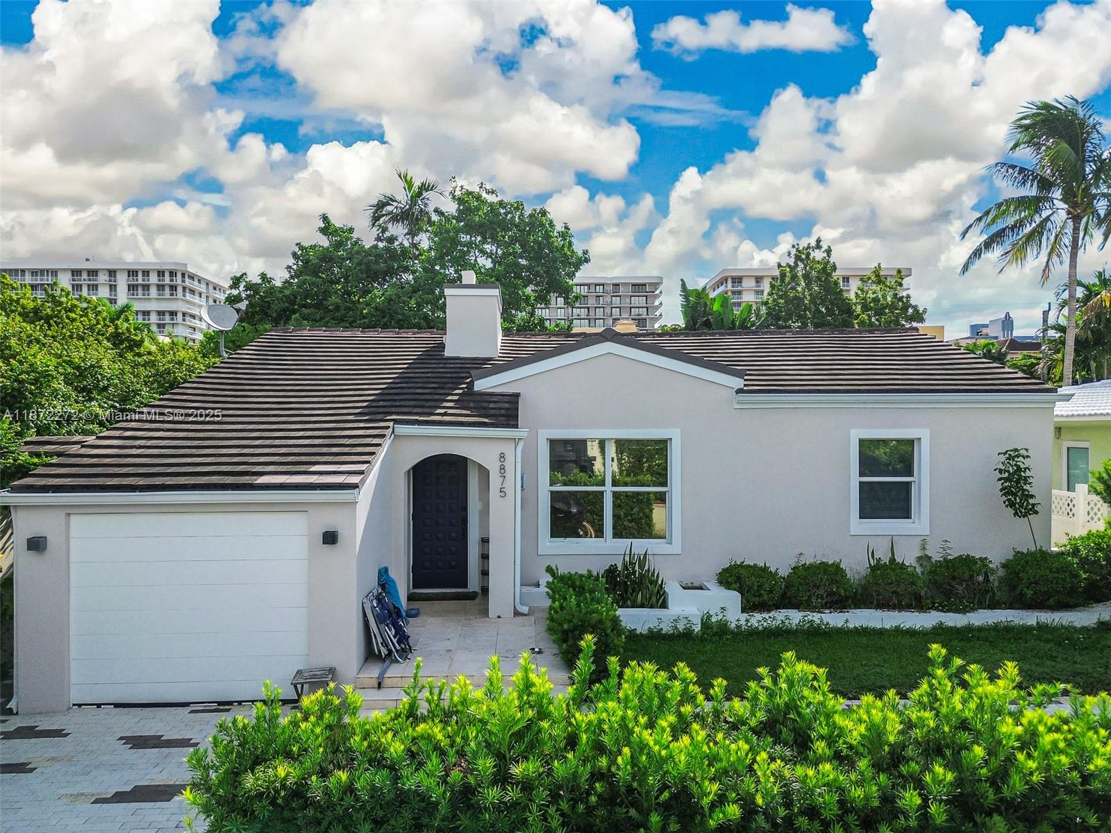8875 Abbott Avenue Surfside, FL 33154 - Photo 3 of 45 a front view of a house with a yard