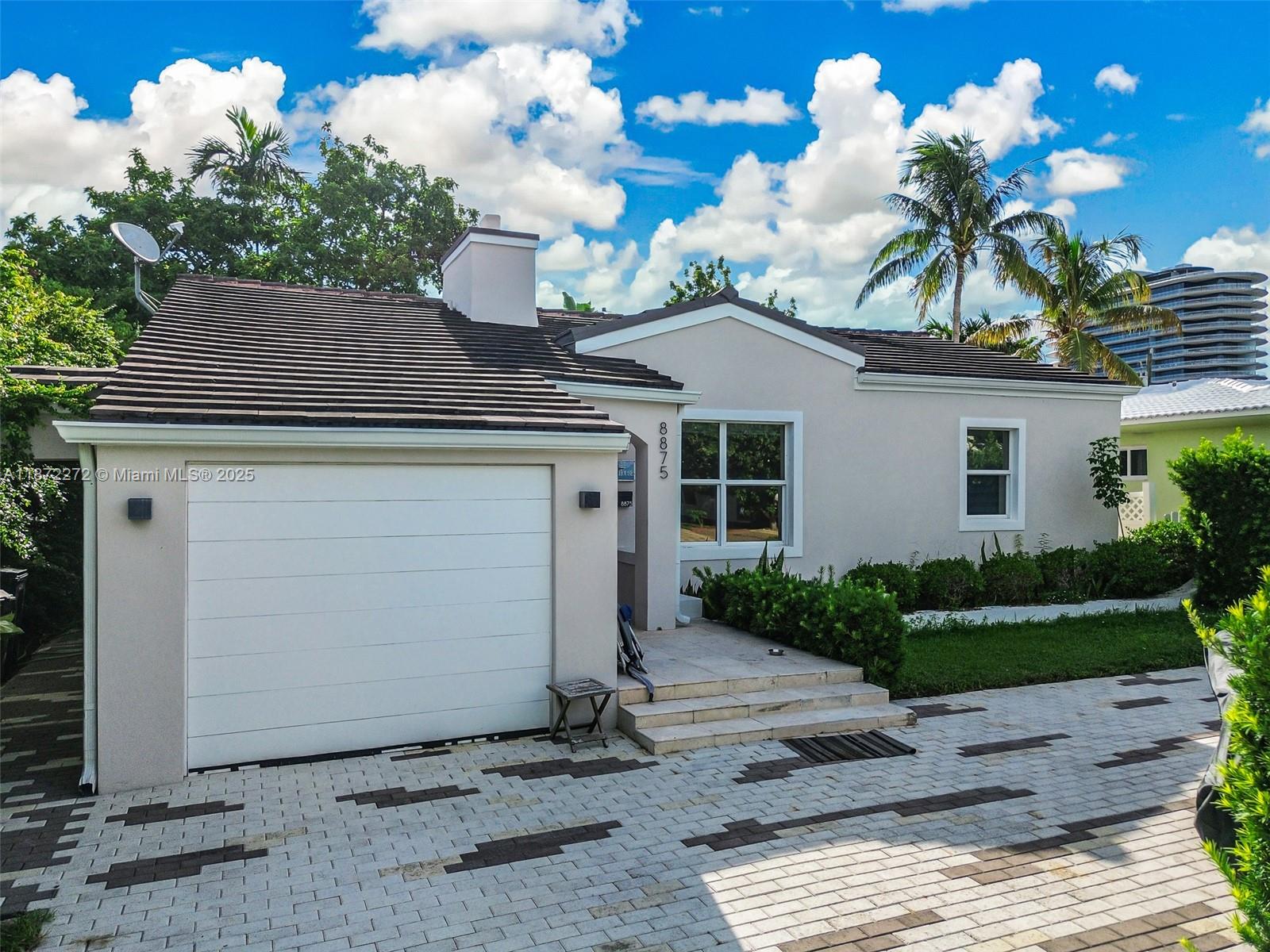 8875 Abbott Avenue Surfside, FL 33154 - Photo 5 of 45 a front view of a house with a garden