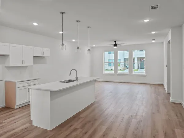a kitchen with stainless steel appliances granite countertop a sink a stove and wooden floor