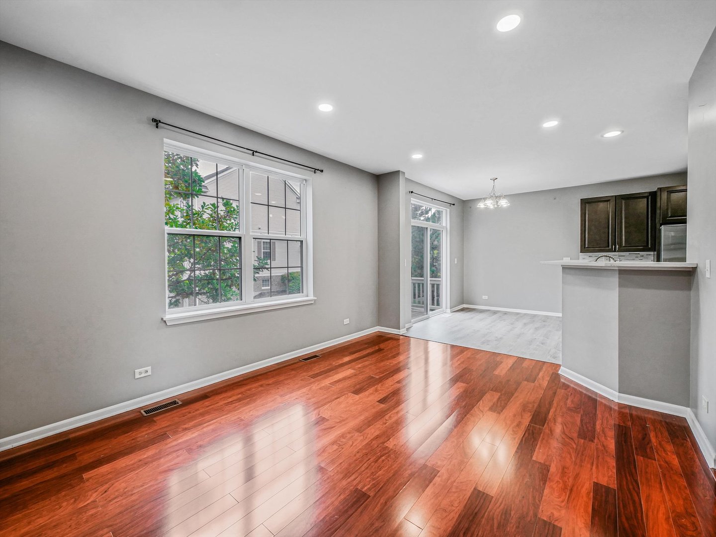 1090 Maubert Court Carol Stream, IL 60188 - Photo 9 of 55 a view of an empty room with a window and wooden floor