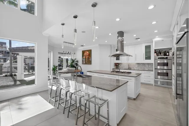 a kitchen with granite countertop white cabinets and stainless steel appliances