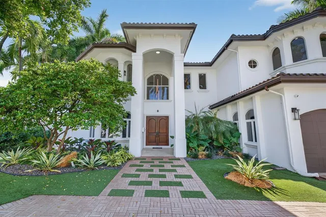 a view of a white house with a yard and large tree