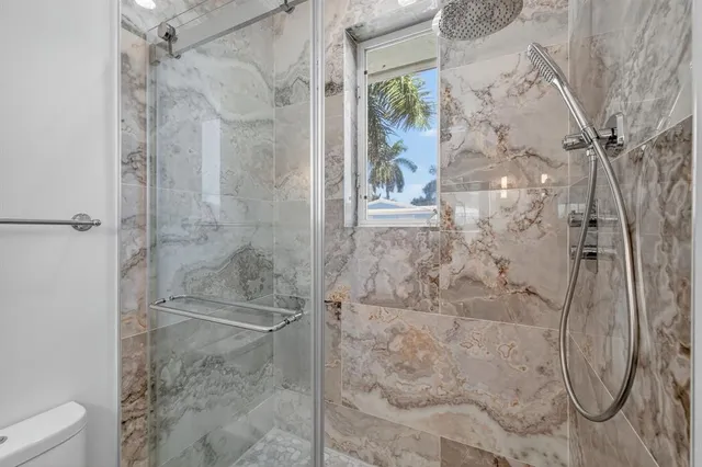 a bathroom with a toilet a sink and shower