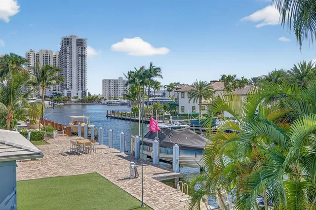 a view of a swimming pool with a lawn chairs under palm trees