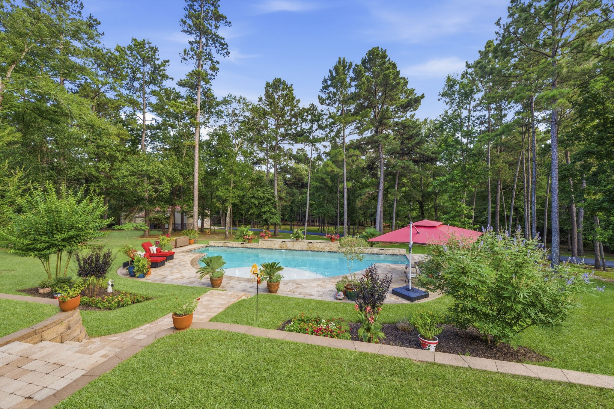 280 Sundog Road Huntsville, TX 77340 - Photo 45 of 50 Elevated view from the covered patio showcasing the pool and spacious backyard setting.