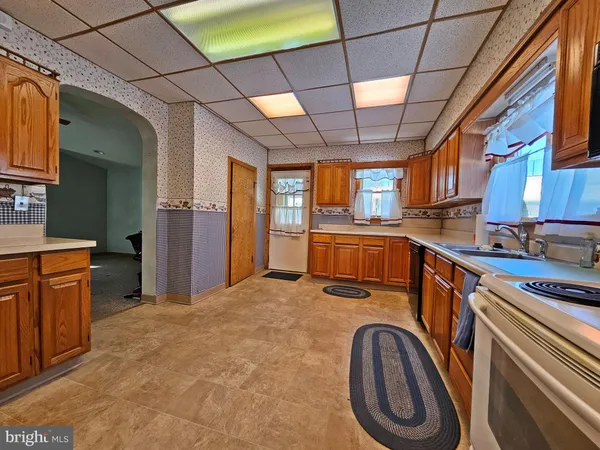 a view of a kitchen with stainless steel appliances granite countertop a sink and cabinets