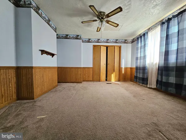 a view of a livingroom with a ceiling fan and window
