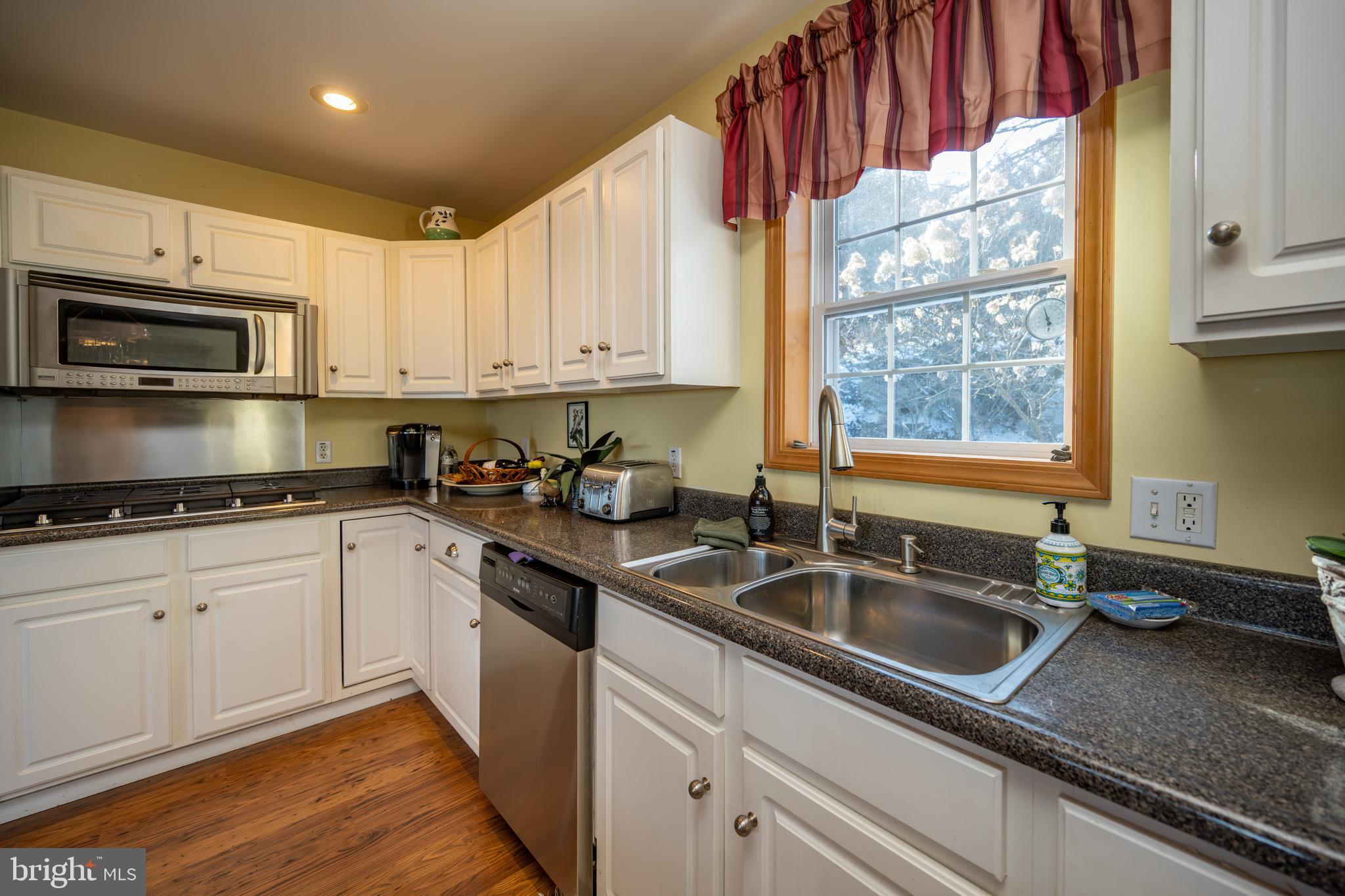3836 Chestnut Grove Road Swanton, MD 21561 - Photo 60 of 111 a kitchen with granite countertop a sink stainless steel appliances and cabinets