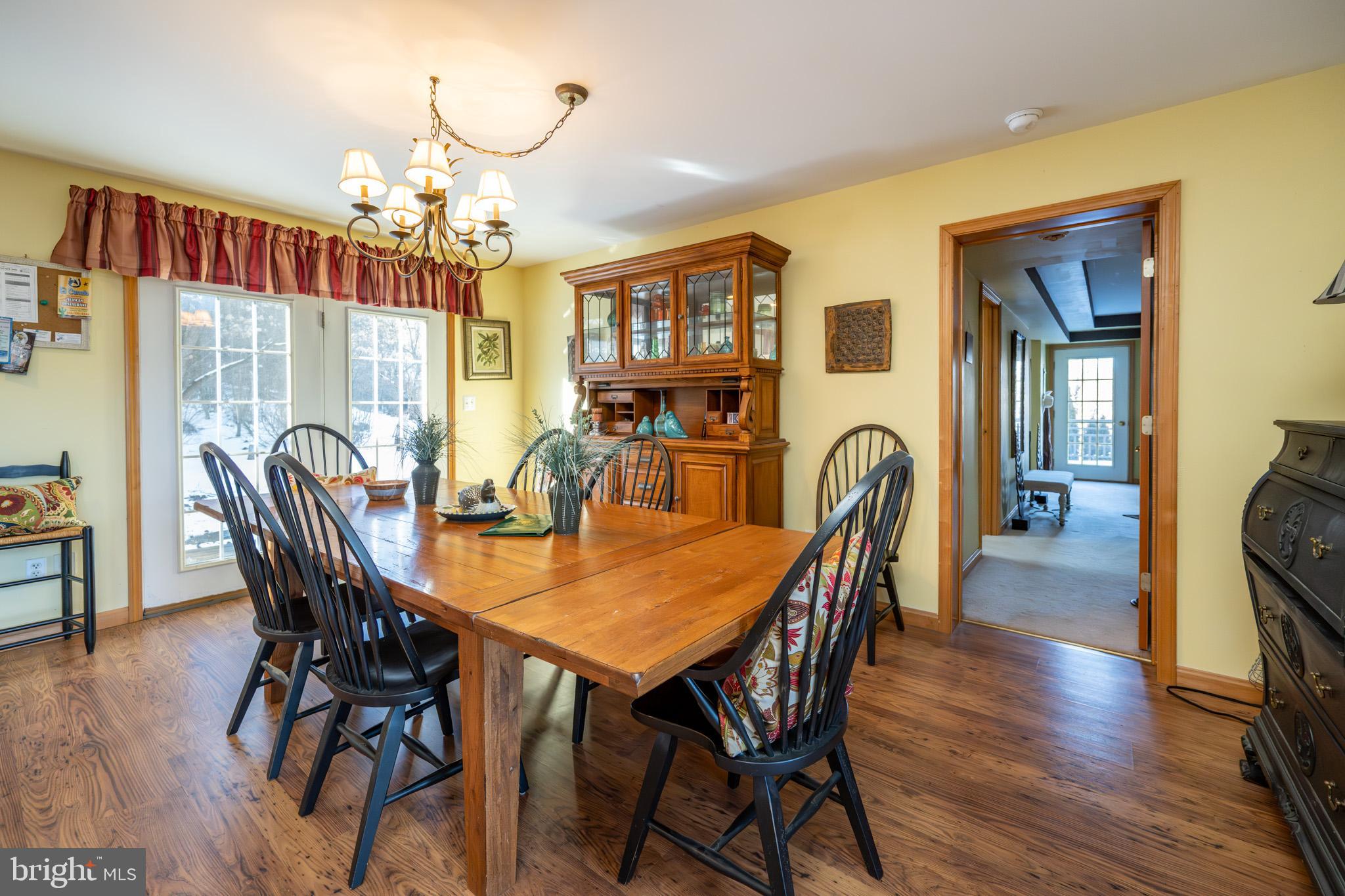 3836 Chestnut Grove Road Swanton, MD 21561 - Photo 64 of 111 a view of a dining room with furniture wooden floor and chandelier