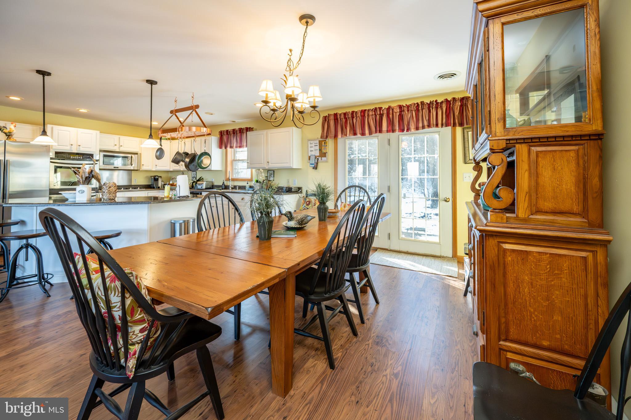 3836 Chestnut Grove Road Swanton, MD 21561 - Photo 65 of 111 a dining room with furniture a chandelier and wooden floor