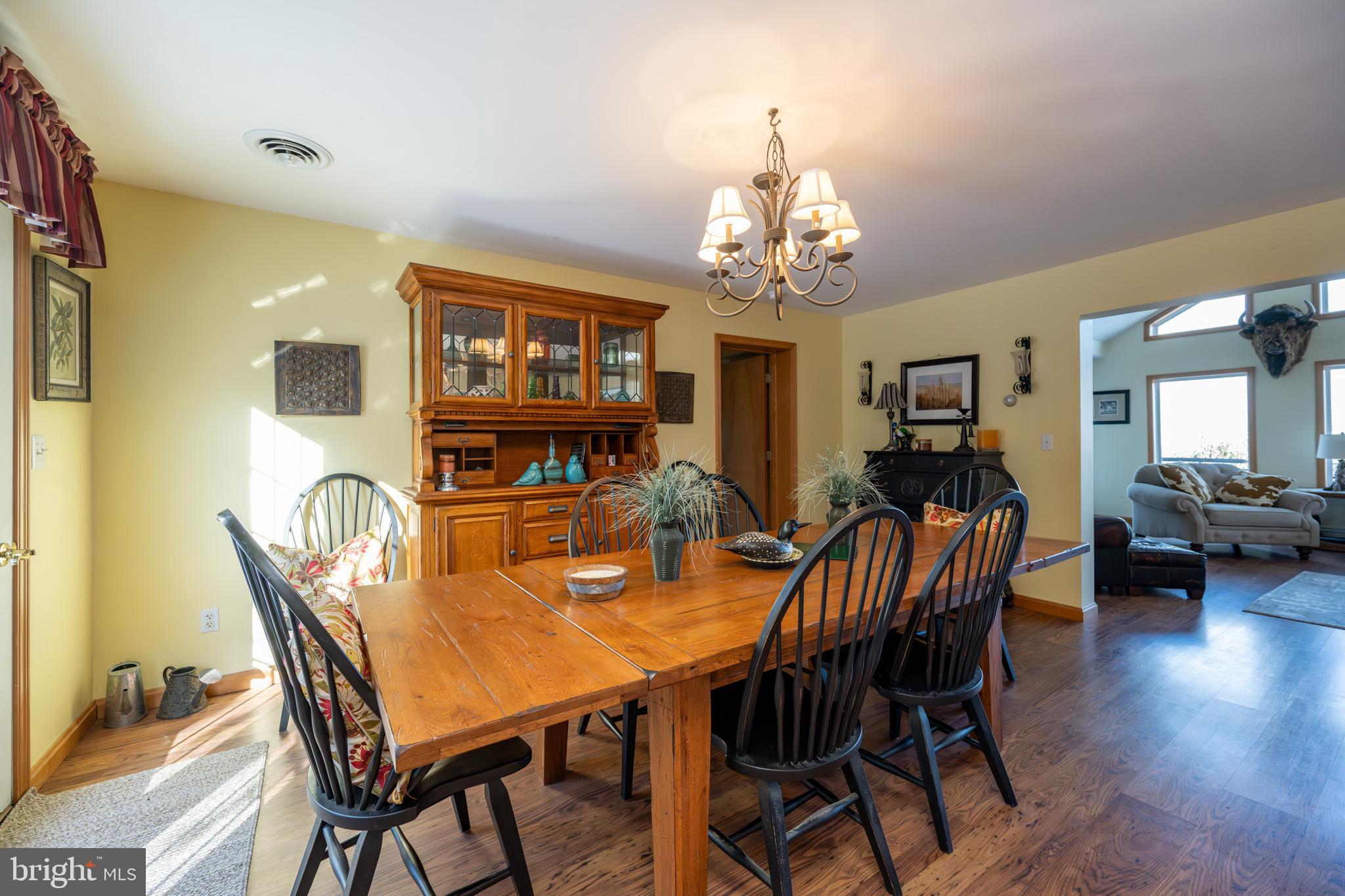 3836 Chestnut Grove Road Swanton, MD 21561 - Photo 67 of 111 a view of a dining room with furniture a chandelier and wooden floor