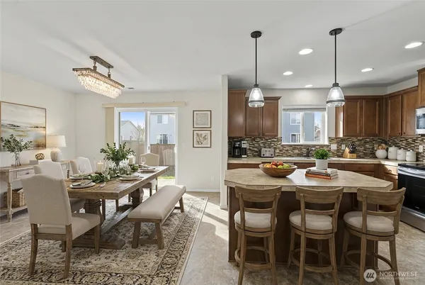 a dining room with stainless steel appliances kitchen island a table and chairs