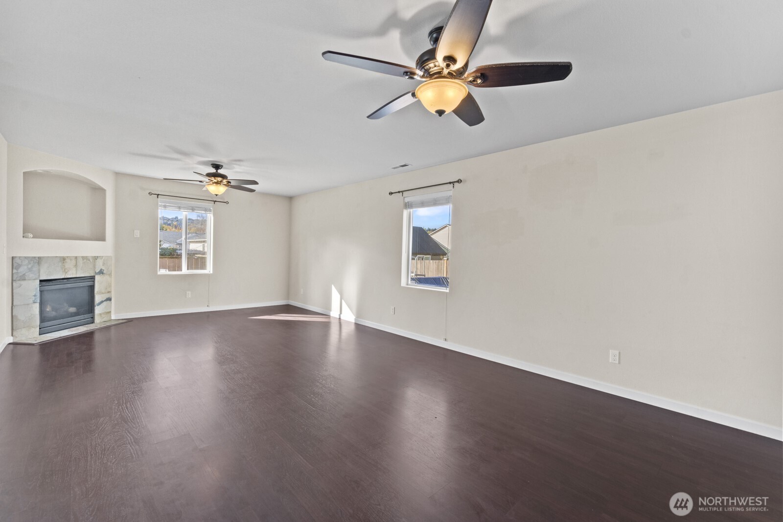 1105 Sigafoos Avenue Northwest Orting, WA 98360 - Photo 6 of 40 an empty room with wooden floor fan and windows