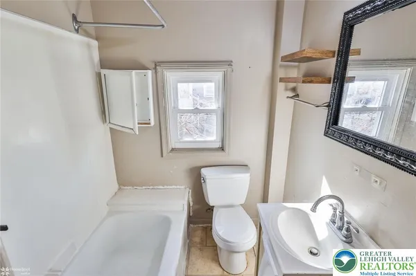 a white toilet sitting next to a bathroom sink