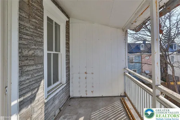 an empty room with wooden floor and window