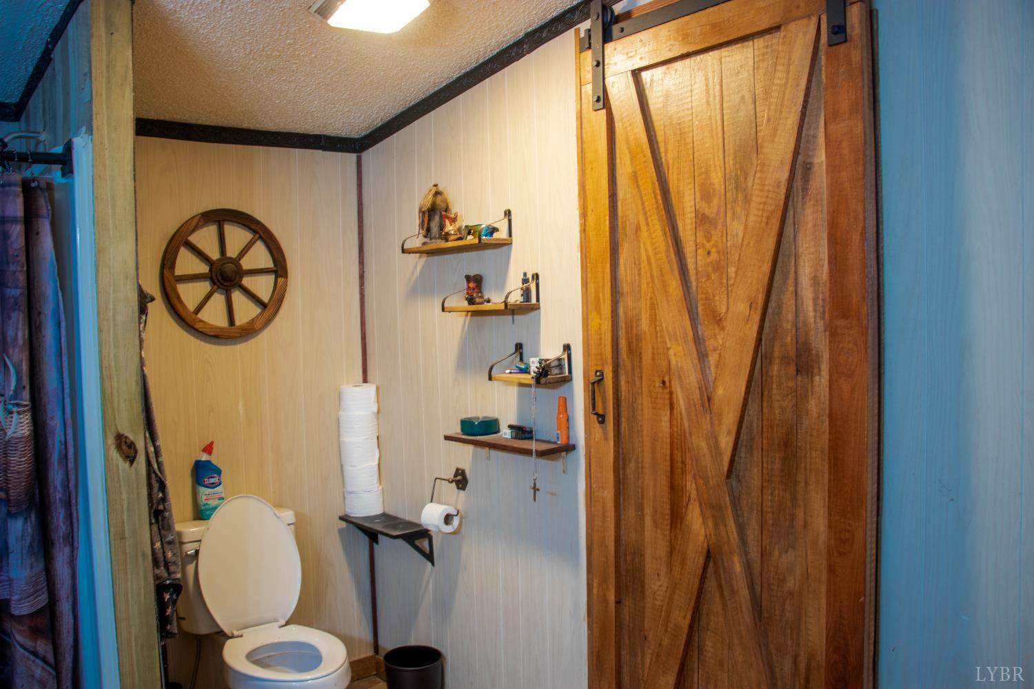 3156 Owens Mill Road Gretna, VA 24557 - Photo 18 of 31 a bathroom with a toilet and a shower curtain