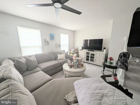 a living room with furniture a flat screen tv and a window