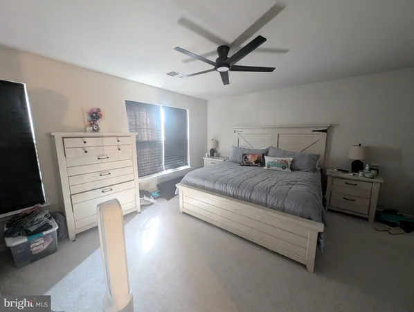 a bedroom with a bed and a flat tv screen on the dresser