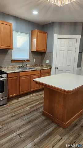 a large kitchen with stainless steel appliances granite countertop a sink and a stove