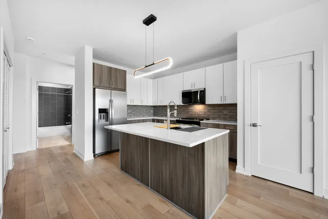 a kitchen with stainless steel appliances a stove a refrigerator and a sink