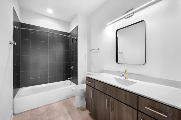 a bathroom with a bathtub shower sink and mirror