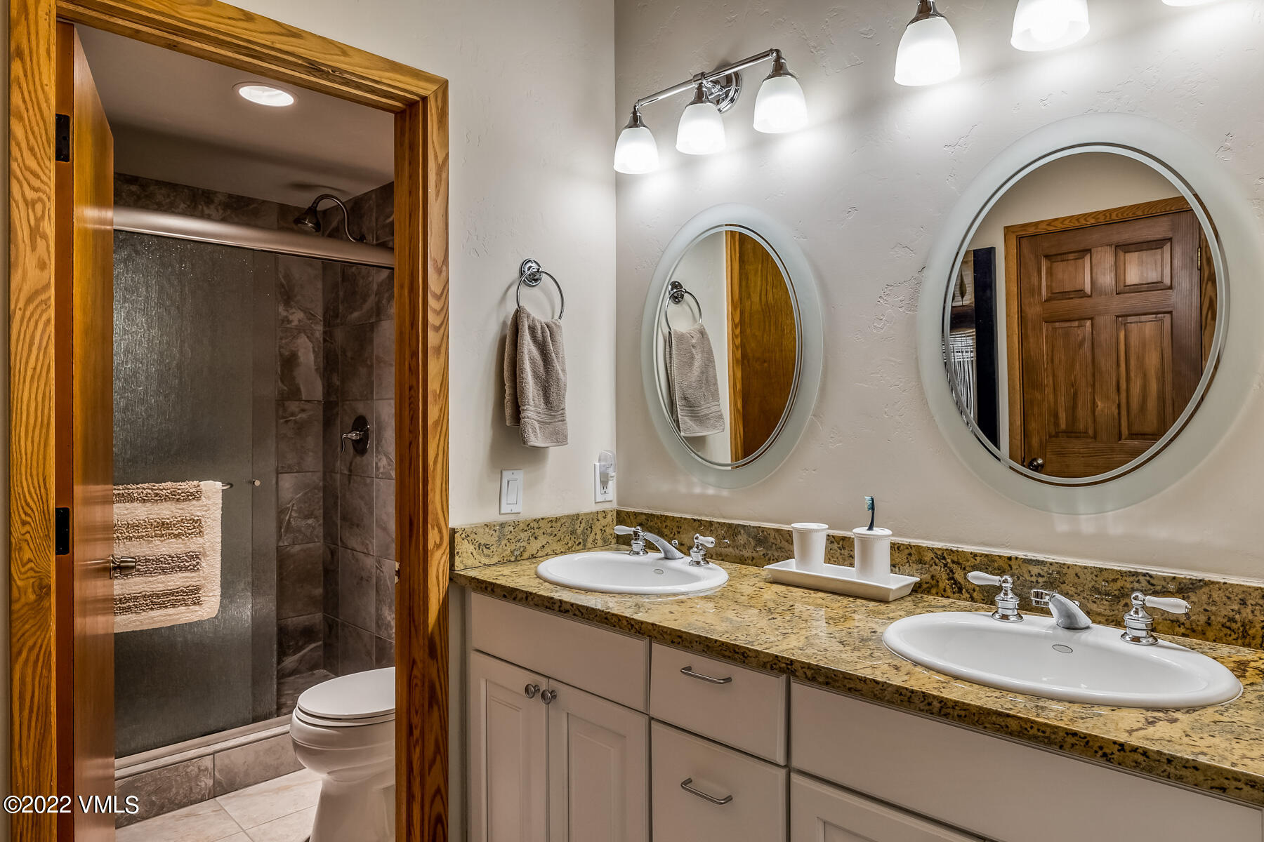 8 Deer Boulevard Eagle-Vail, CO 81620 - Photo 19 of 34 a bathroom with a granite countertop toilet a sink and a mirror