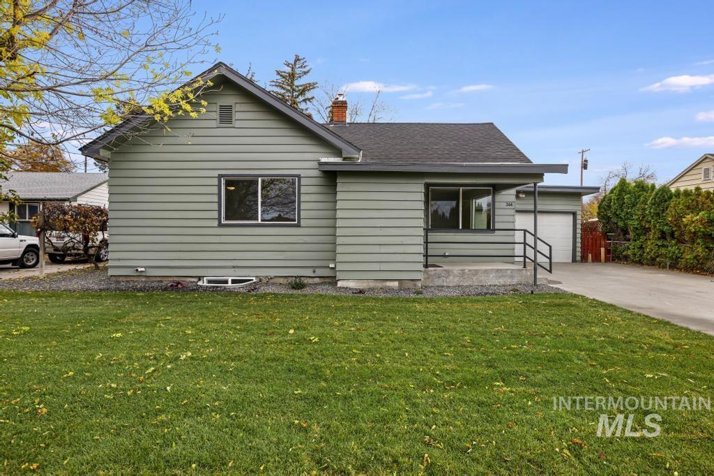 344 Fillmore Street Twin Falls, ID 83301 - Photo 33 of 42 View of front of home with a front yard, a chimney, concrete driveway, and roof with shingles