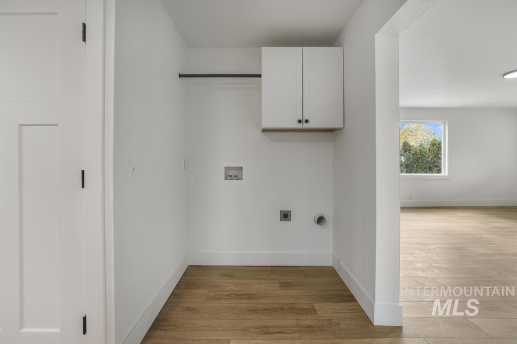 344 Fillmore Street Twin Falls, ID 83301 - Photo 9 of 42 Laundry room with light wood-style flooring, cabinet space, washer hookup, and electric dryer hookup