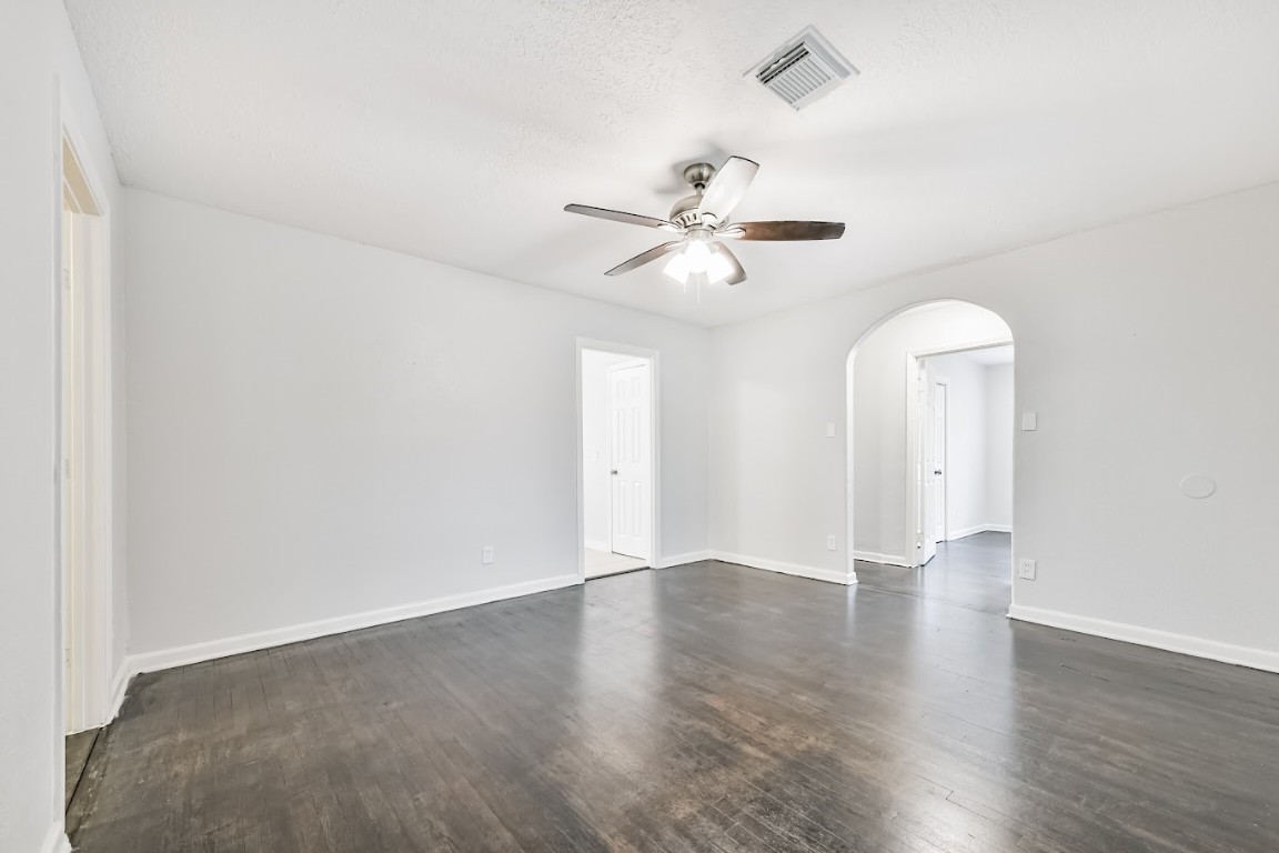 5855 Beldart Street Houston, TX 77033 - Photo 13 of 26 an empty room with wooden floor ceiling fan and window