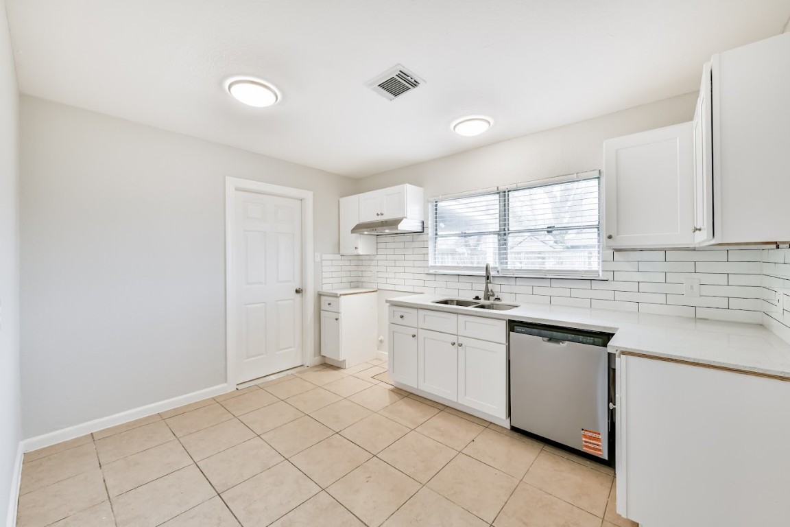 5855 Beldart Street Houston, TX 77033 - Photo 15 of 26 a kitchen with a sink cabinets and window