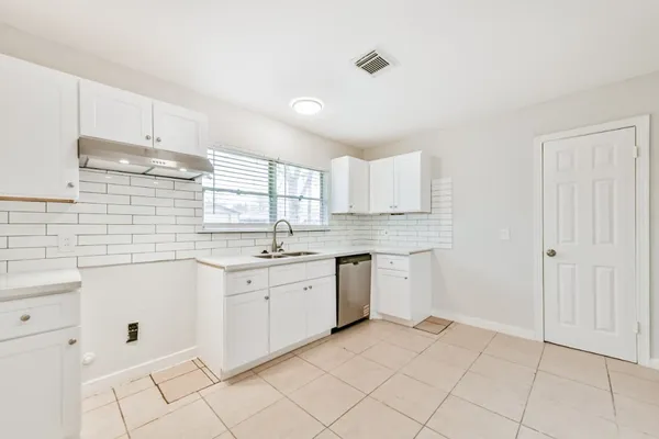 a kitchen with granite countertop white cabinets white stainless steel appliances with a sink and dishwasher