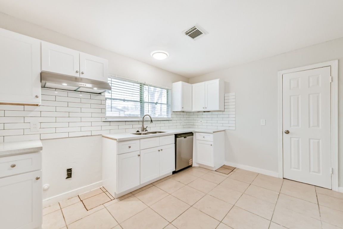 5855 Beldart Street Houston, TX 77033 - Photo 16 of 26 a kitchen with granite countertop white cabinets white stainless steel appliances with a sink and dishwasher