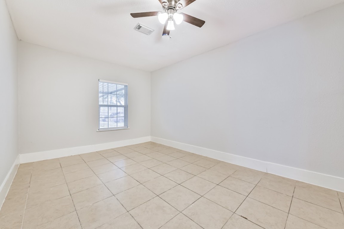 5855 Beldart Street Houston, TX 77033 - Photo 17 of 26 an empty room with windows and fan