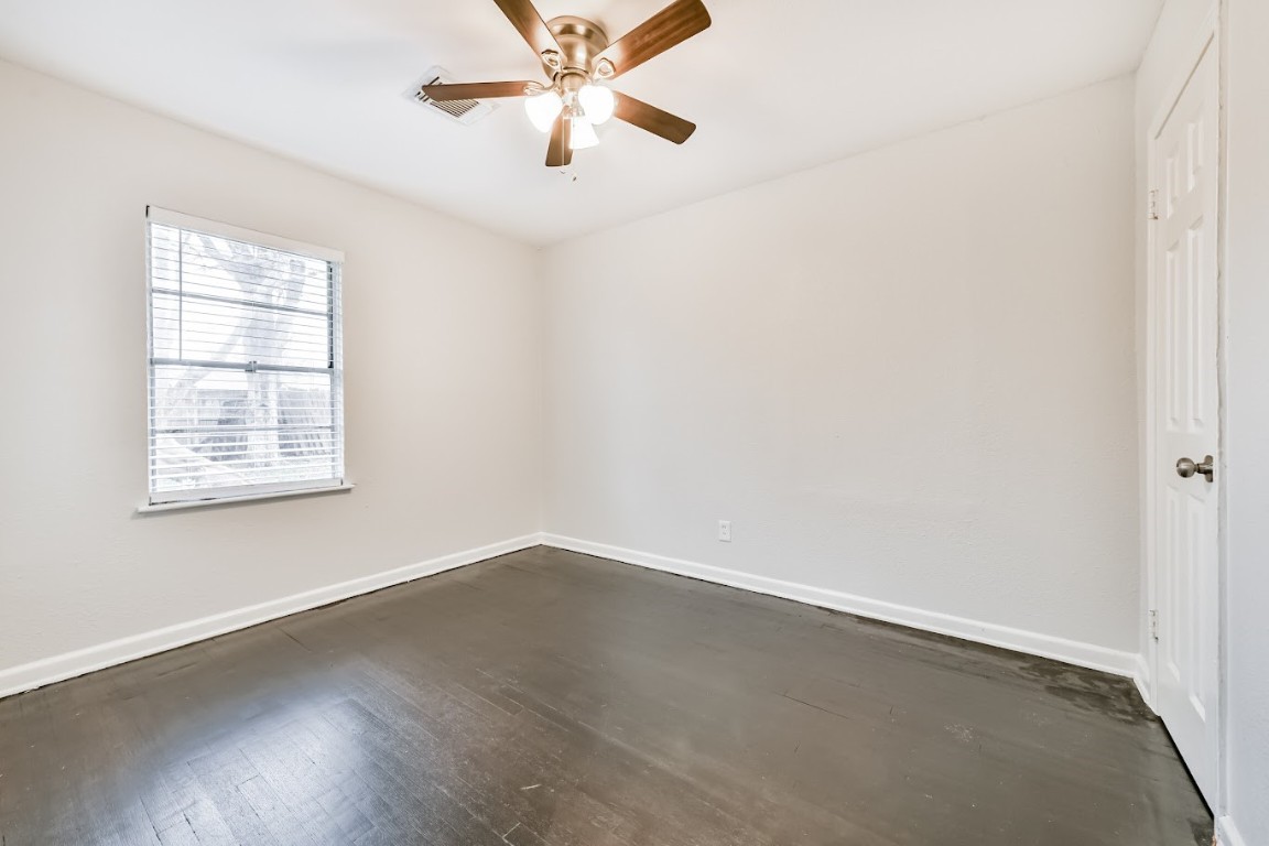 5855 Beldart Street Houston, TX 77033 - Photo 20 of 26 an empty room with wooden floor fan and windows