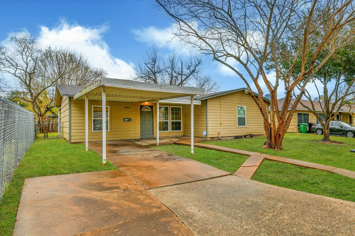 5855 Beldart Street Houston, TX 77033 - Photo 2 of 26 a view of a yard in front of a house with a large tree
