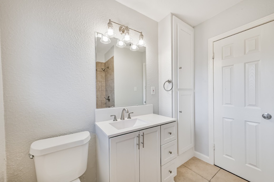 5855 Beldart Street Houston, TX 77033 - Photo 25 of 26 a bathroom with a toilet a sink a mirror and vanity