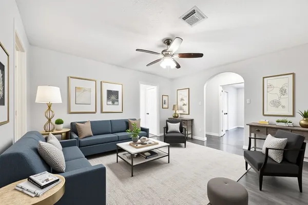 a living room with furniture ceiling fan and a window