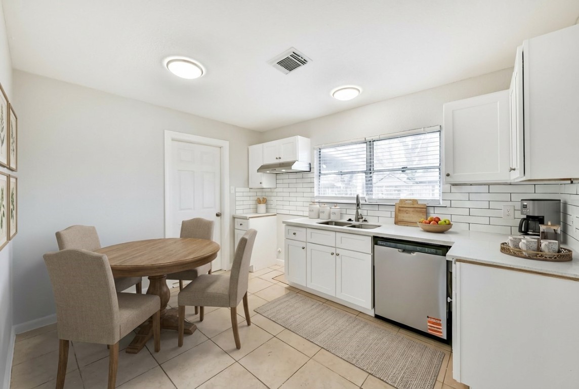 5855 Beldart Street Houston, TX 77033 - Photo 6 of 26 a kitchen with stainless steel appliances granite countertop a sink a stove a dining table and chairs