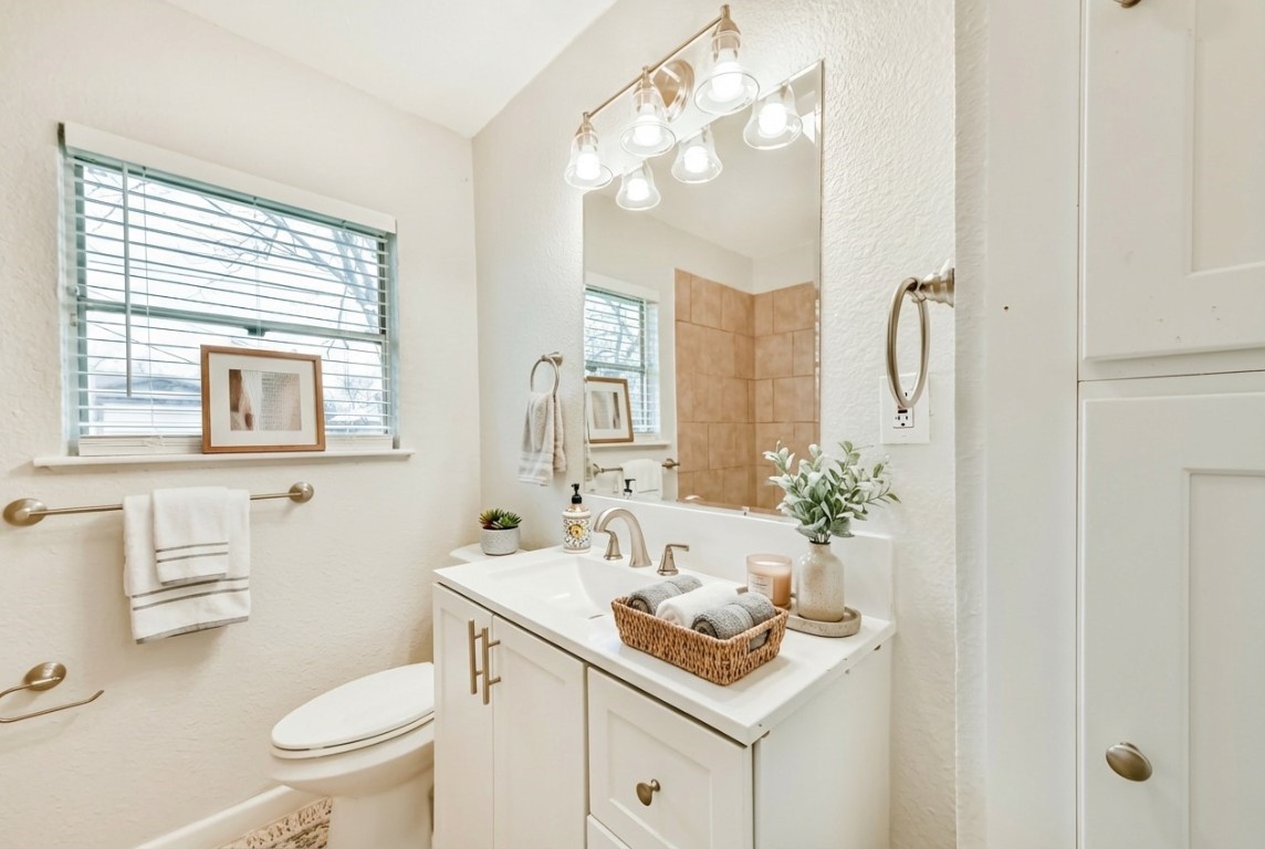 5855 Beldart Street Houston, TX 77033 - Photo 10 of 26 a bathroom with a sink toilet vanity and shower