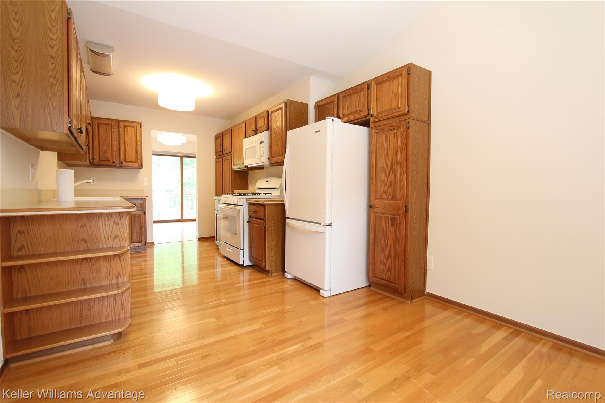 21850 River Ridge Trail Farmington, MI 48335 - Photo 13 of 33 Spacious kitchen featuring wood-finish flooring, wood cabinetry, and a full suite of white appliances