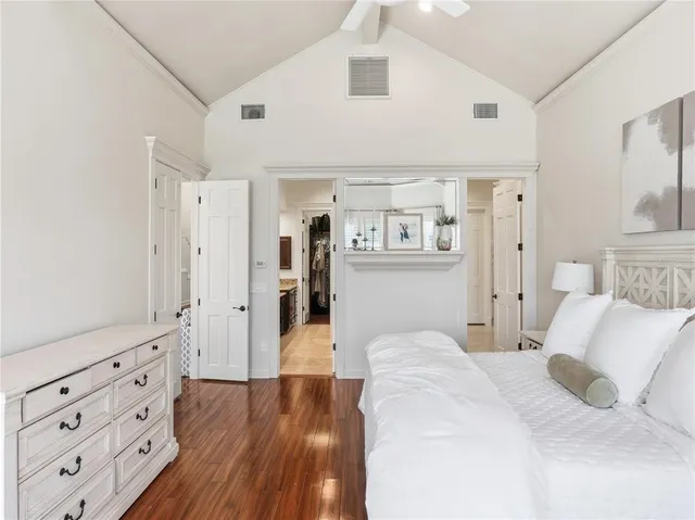 a spacious bedroom with a bed and wooden floor