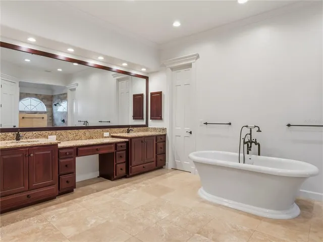 a bathroom with a granite countertop double vanity and a mirror
