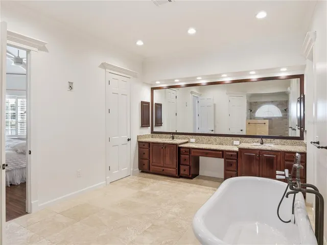 a large bathroom with a tub a double vanity sink a mirror and a shower