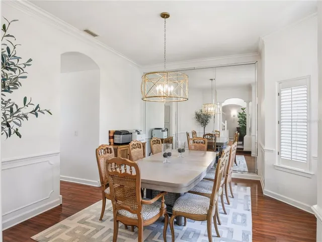 a dining room with furniture a chandelier and wooden floor