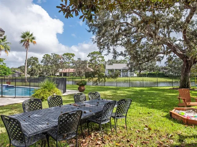 a view of a chairs and table in patio with a lake view