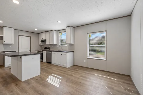 a kitchen with stainless steel appliances a refrigerator sink and microwave